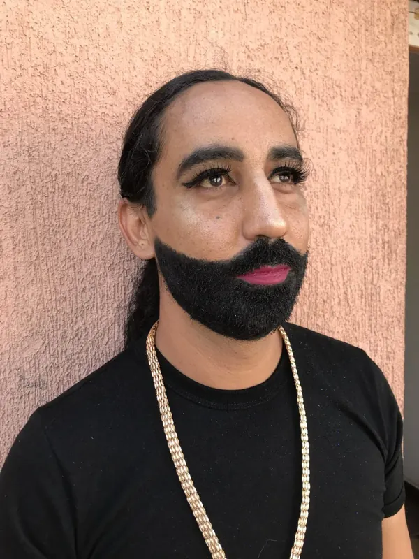 Caracterización de carnaval con barba negra, pestañas largas y labios fucsia