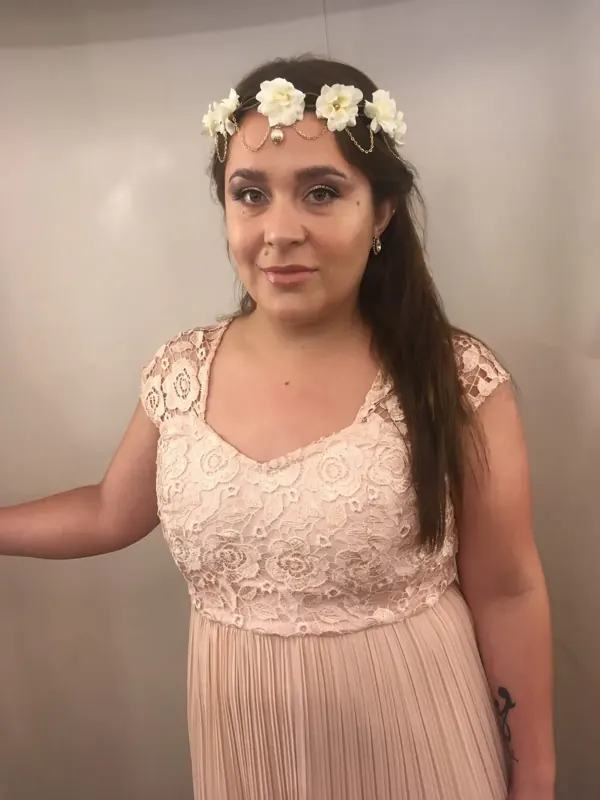 Maquillaje suave con corona de flores blancas y vestido rosado