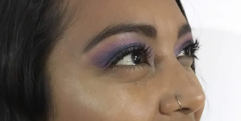 Primer plano de un ojo con sombra lila y morada difuminada